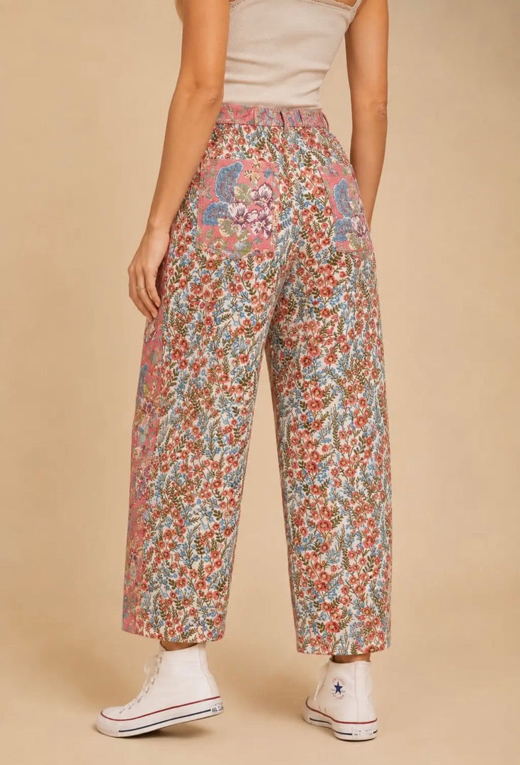 Pantalón de mujer de talle alto y pierna amplia con estampado floral patchwork en tonos rosa, azul y crema, bolsillos delanteros y traseros.