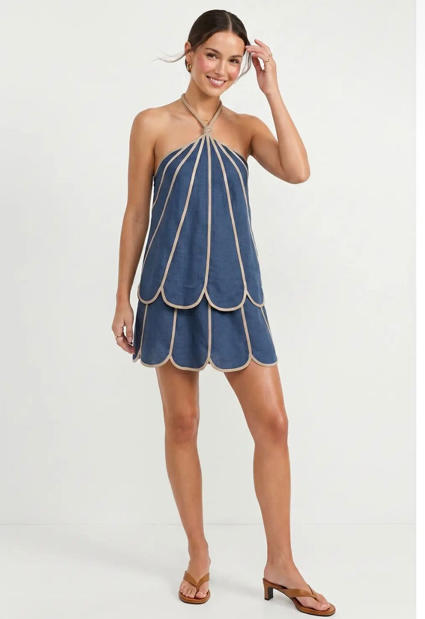 Conjunto de mujer azul con detalles beige, blusa halter de tirantes ajustables y terminaciones en forma de pétalos, acompañado de falda corta con pantalón interior.