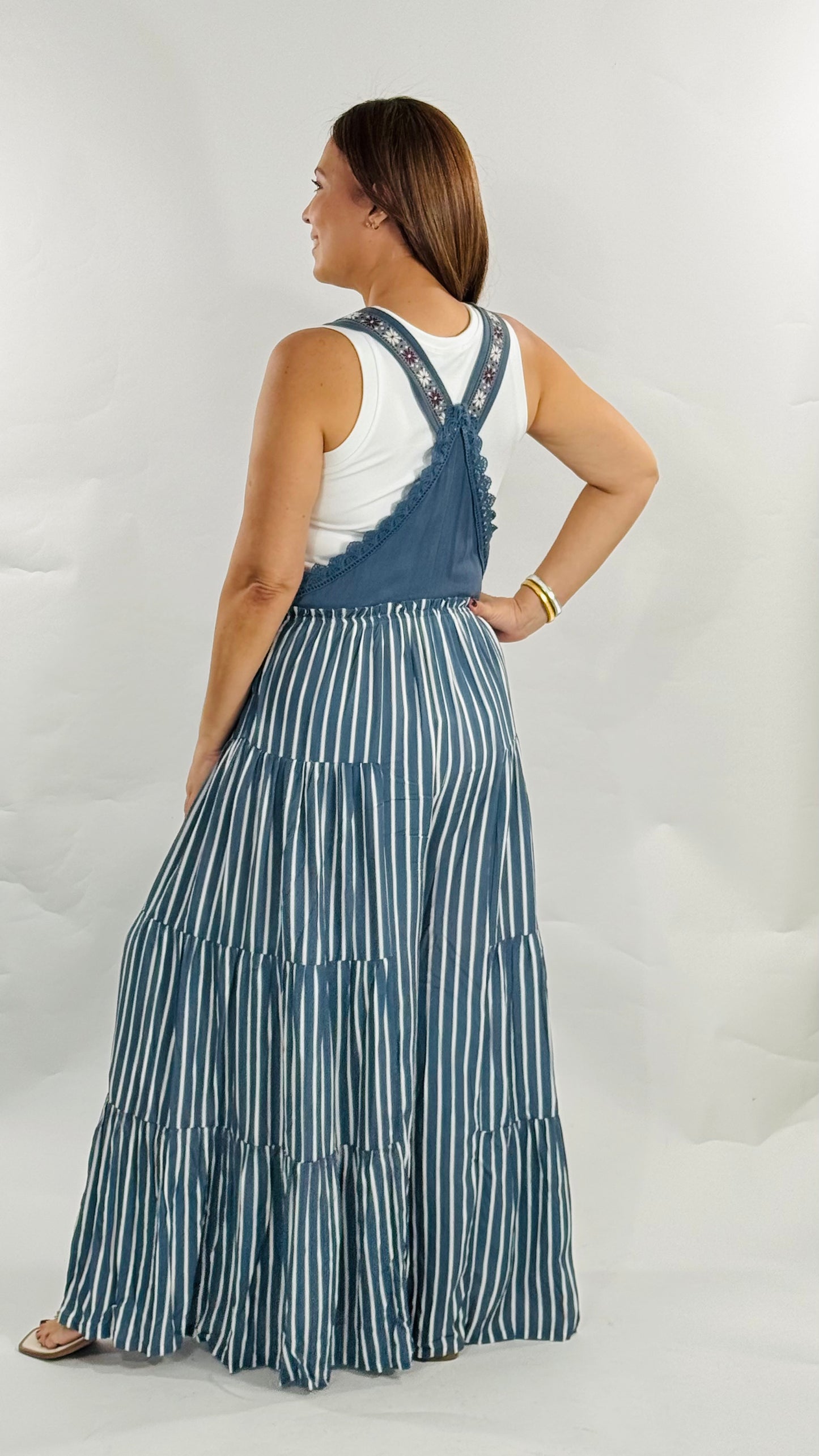 Overall jumpsuit azul con tirantes bordados y pierna ancha de caída fluida.