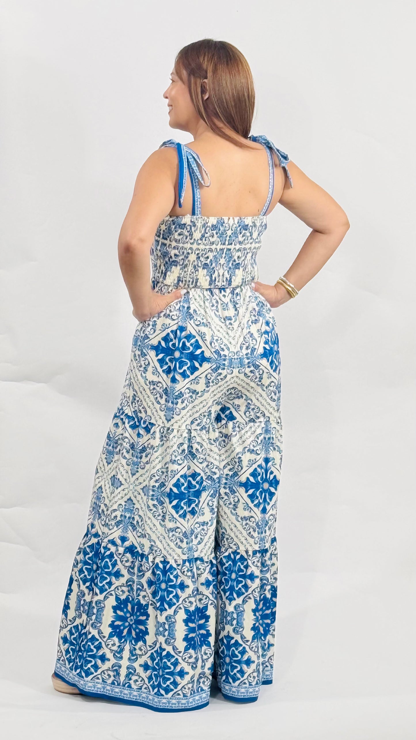 Jumpsuit de algodón con estampado azul y blanco, tirantes ajustables, pantalón largo y parte posterior con elástico para mejor ajuste.