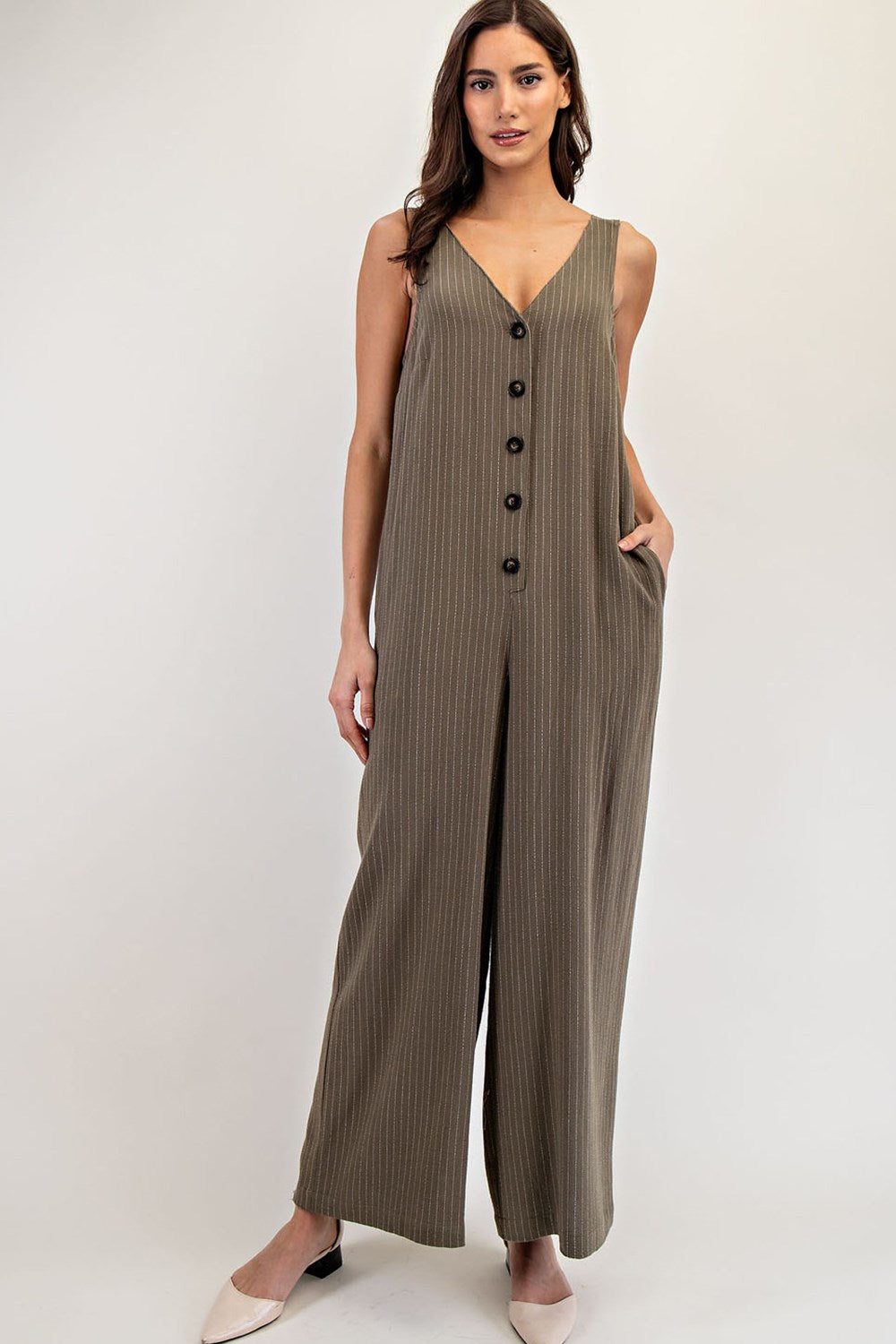 Jumpsuit largo de rayas con botones frontales, bolsillos y diseño amplio en tela fresca.