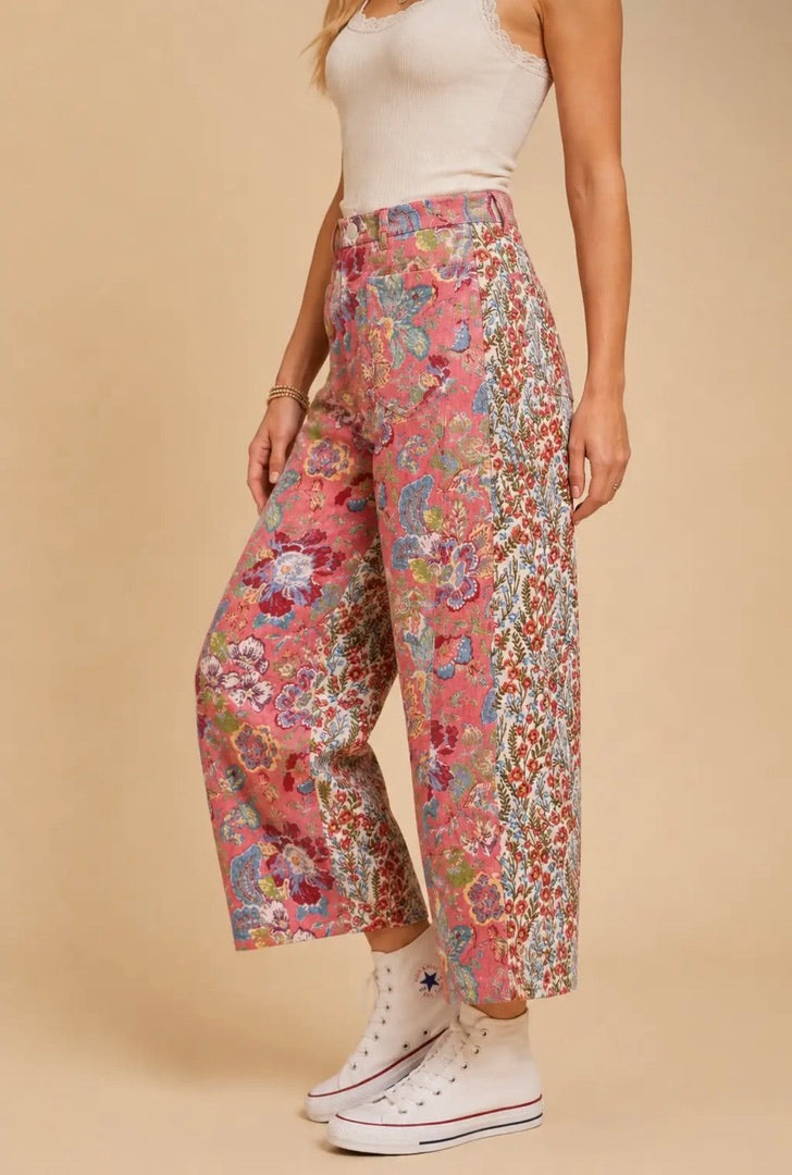 Pantalón de mujer de talle alto y pierna amplia con estampado floral patchwork en tonos rosa, azul y crema, bolsillos delanteros y traseros.