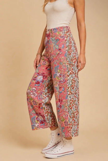 Pantalón de mujer de talle alto y pierna amplia con estampado floral patchwork en tonos rosa, azul y crema, bolsillos delanteros y traseros.