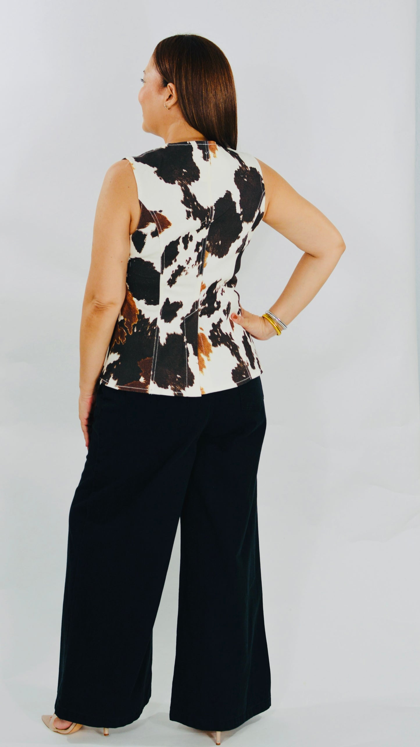 Top tipo vest cow print con botones metálicos decorativos.