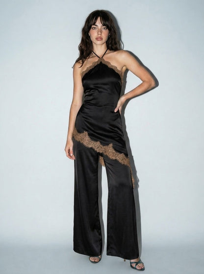 Jumpsuit elegante de mujer en satinado negro con encaje marrón en contraste, cuello halter, detalle asimétrico y pantalón de pierna amplia.
