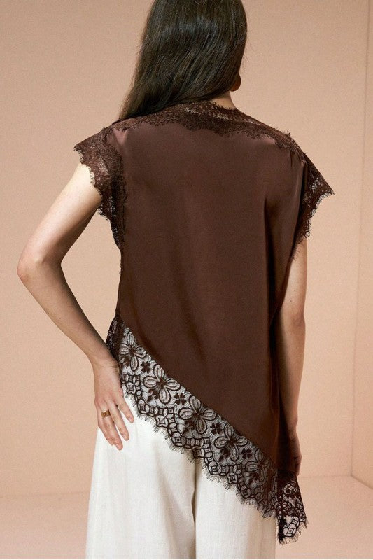 Blusa elegante de mujer color marrón chocolate con encaje floral en el cuello, mangas y ruedo asimétrico.