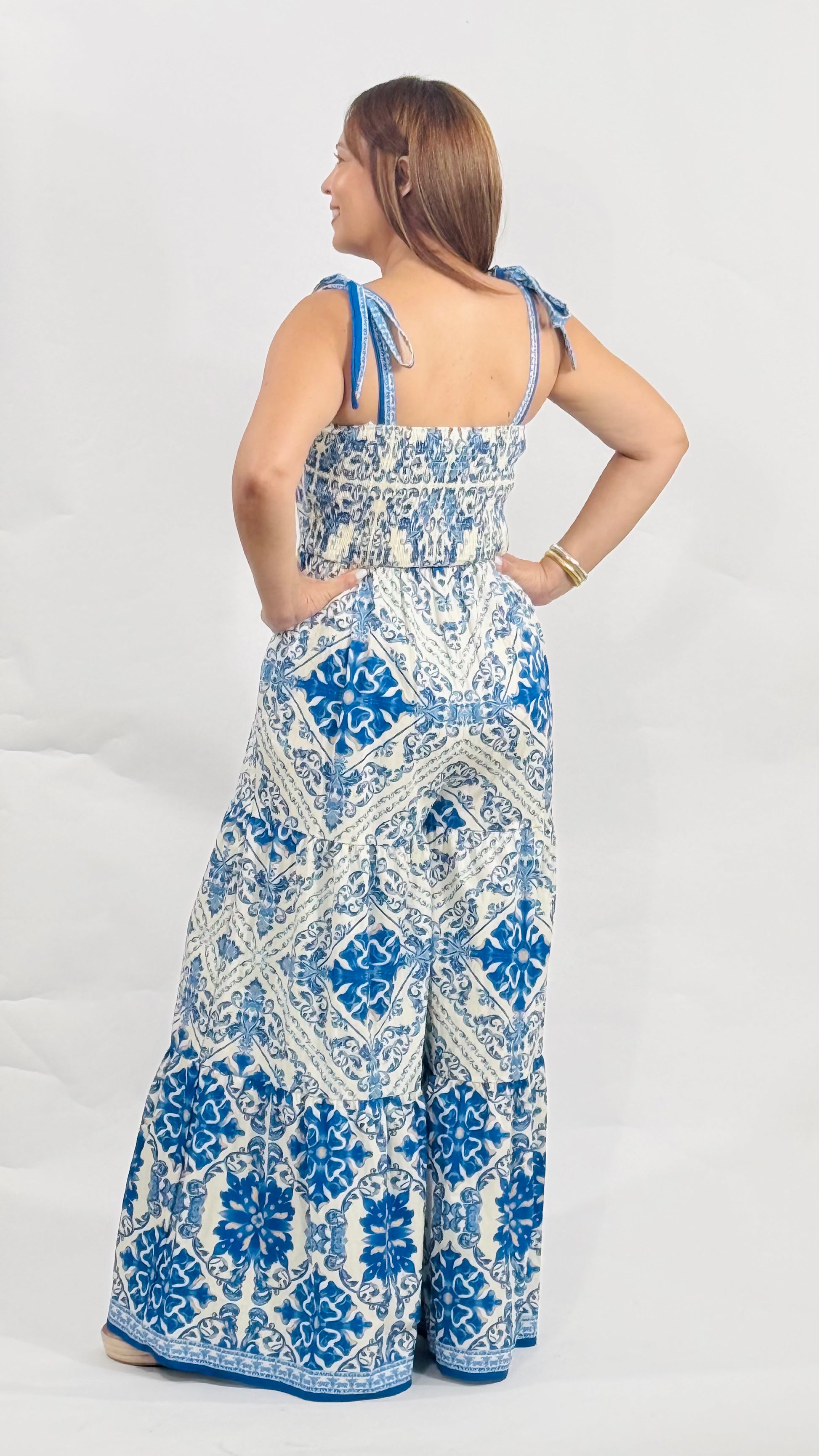 Jumpsuit de algodón con estampado azul y blanco, tirantes ajustables, pantalón largo y parte posterior con elástico para mejor ajuste.