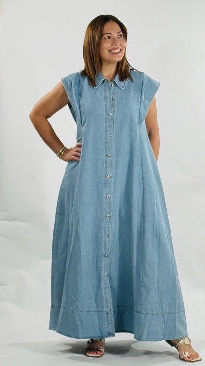 Vestido largo de mahón con botones metálicos decorativos al frente, cuello clásico y bolsillos laterales.