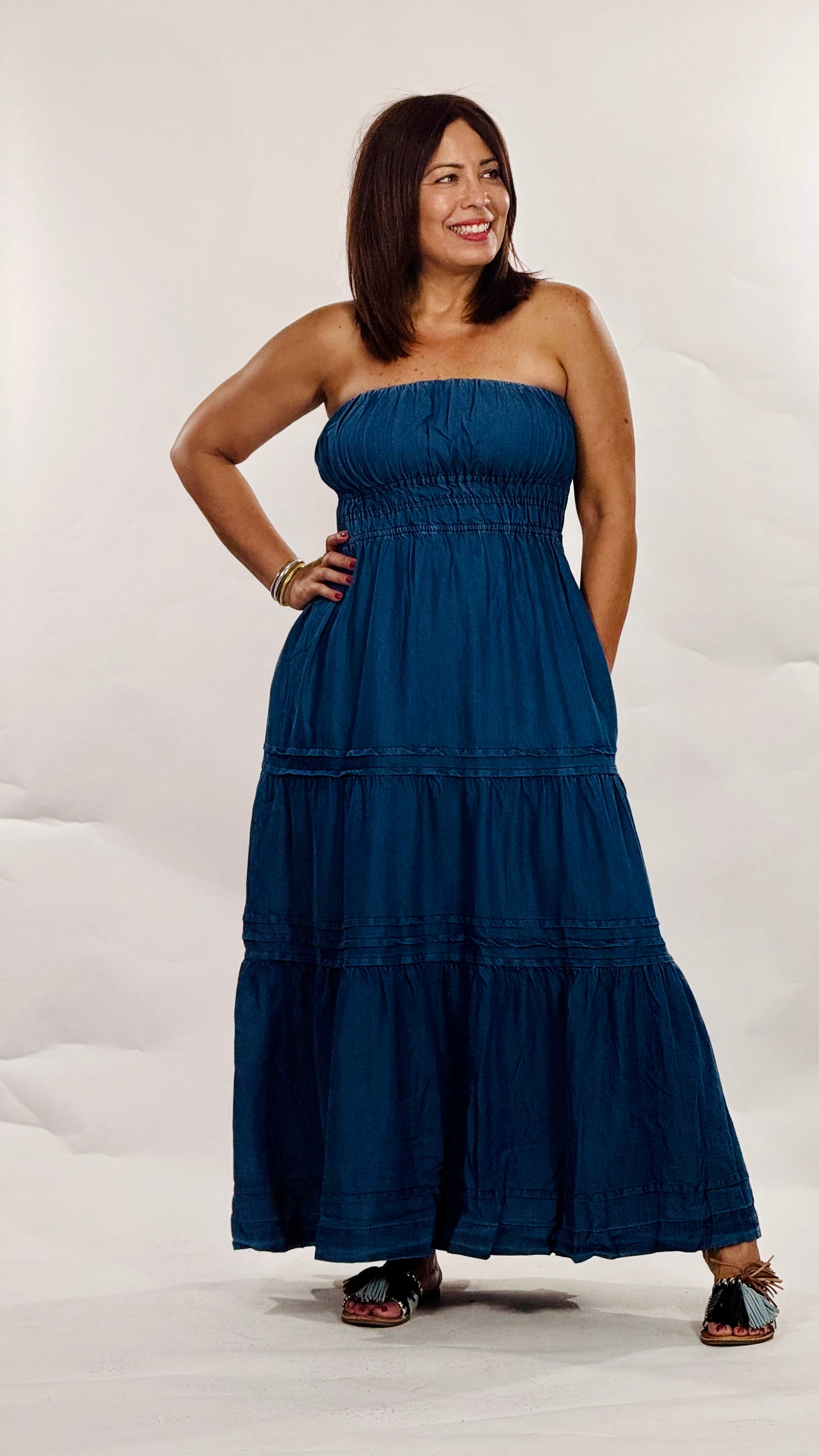 Vestido largo strapless en tela tipo mahón liviana con elástico en el busto, falda en niveles y bolsillos funcionales.