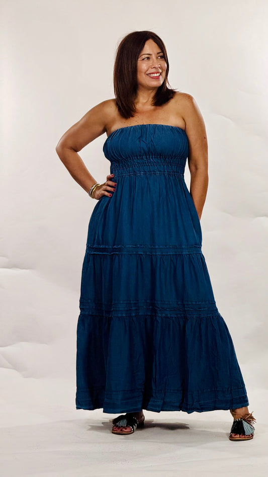 Vestido largo strapless en tela tipo mahón liviana con elástico en el busto, falda en niveles y bolsillos funcionales.