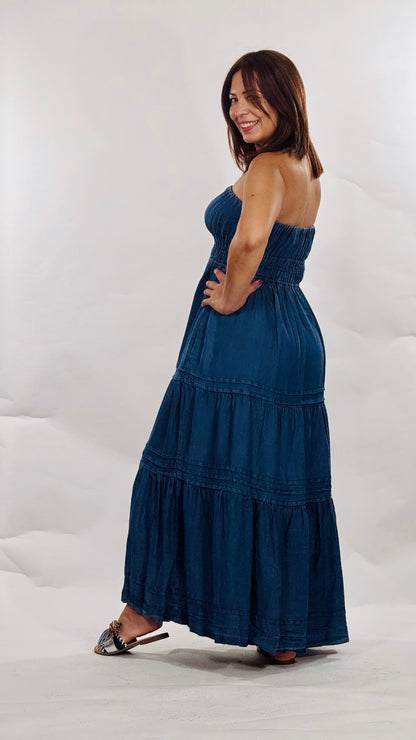Vestido largo strapless en tela tipo mahón liviana con elástico en el busto, falda en niveles y bolsillos funcionales.