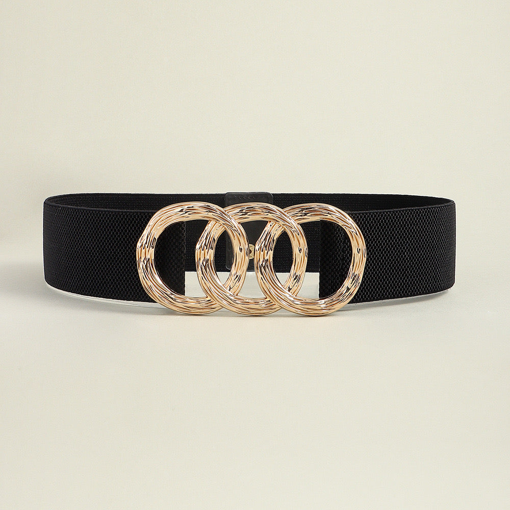 Correa elástica con broche frontal de tres aros metálicos dorados.