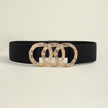 Correa elástica con broche frontal de tres aros metálicos dorados.