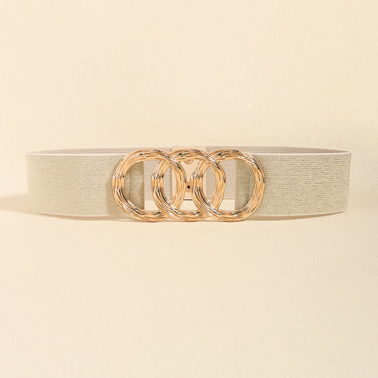 Correa elástica con broche frontal de tres aros metálicos dorados.