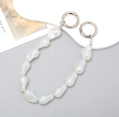 Accesorio tipo chain para celular con diseño de perlas y piezas suaves, ideal para llevar el teléfono en la mano y evitar caídas.