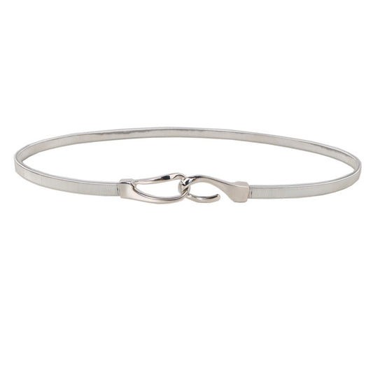 Correa elástica metálica con broche frontal tipo gancho, ideal para definir la cintura y complementar outfits elegantes o casuales.
