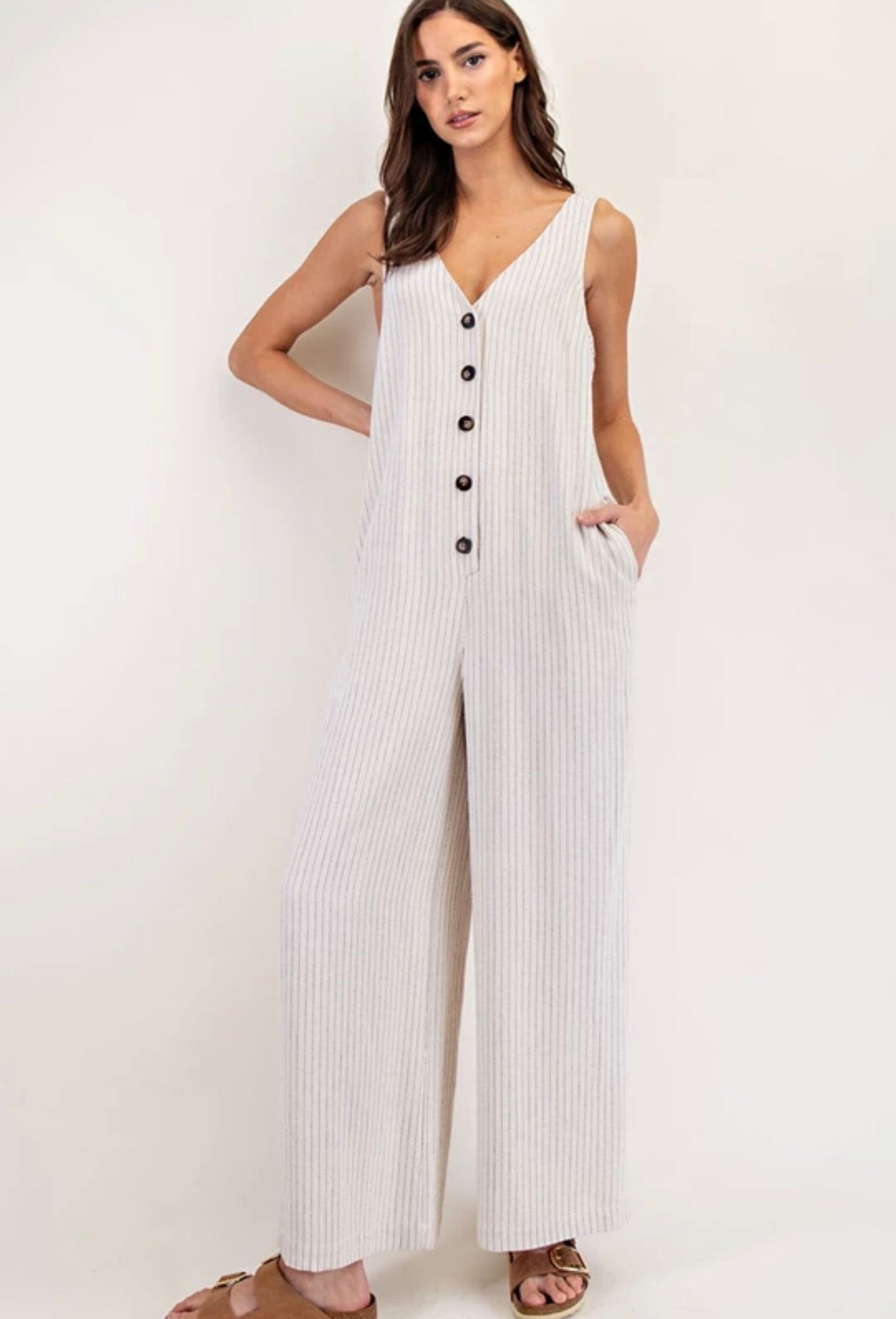 Jumpsuit largo de rayas con botones frontales, bolsillos y diseño amplio en tela fresca.