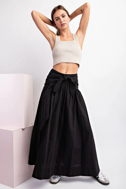 Falda larga negra de algodón con lazo frontal, abertura y elástico en la parte posterior.