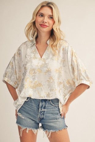 Blusa suelta con mangas amplias, acabado elegante y caída fluida.