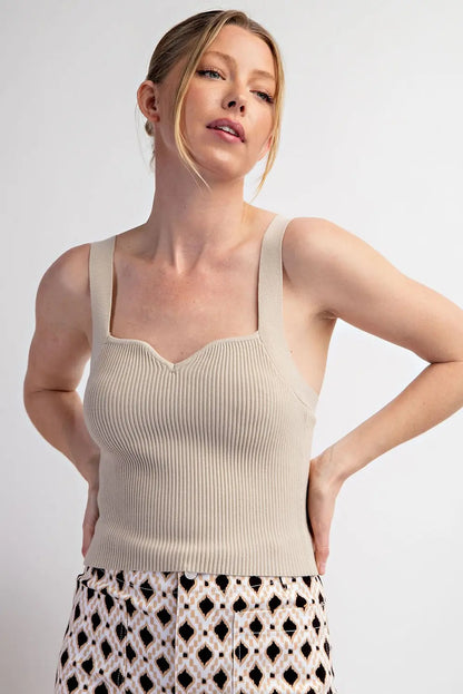 Top básico tejido estilo ribbed con tirantes anchos y escote corazón suave. Diseño ajustado y cómodo ideal para combinar con mahones, faldas o pantalones casuales.