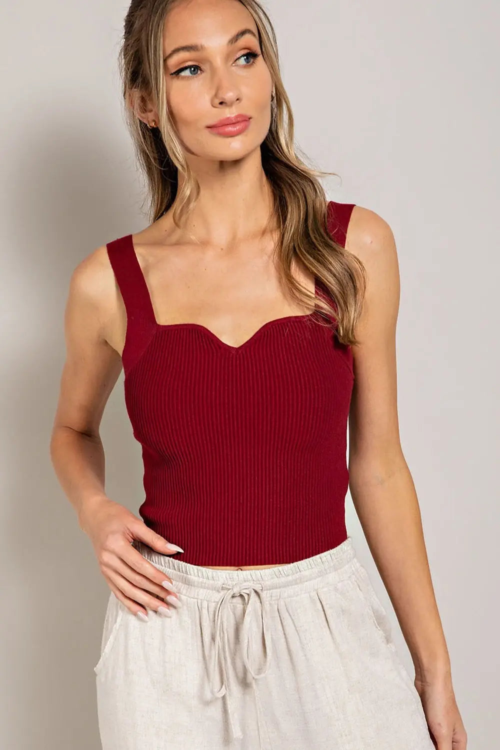 Top básico tejido estilo ribbed con tirantes anchos y escote corazón suave. Diseño ajustado y cómodo ideal para combinar con mahones, faldas o pantalones casuales.