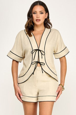 Set color beige con detalles negros en contraste, top amplio de mangas cortas y short cómodo con elástico posterior.