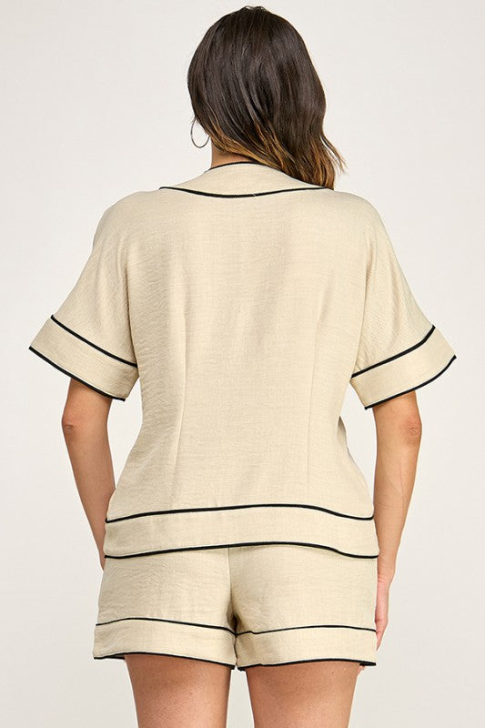Set color beige con detalles negros en contraste, top amplio de mangas cortas y short cómodo con elástico posterior.