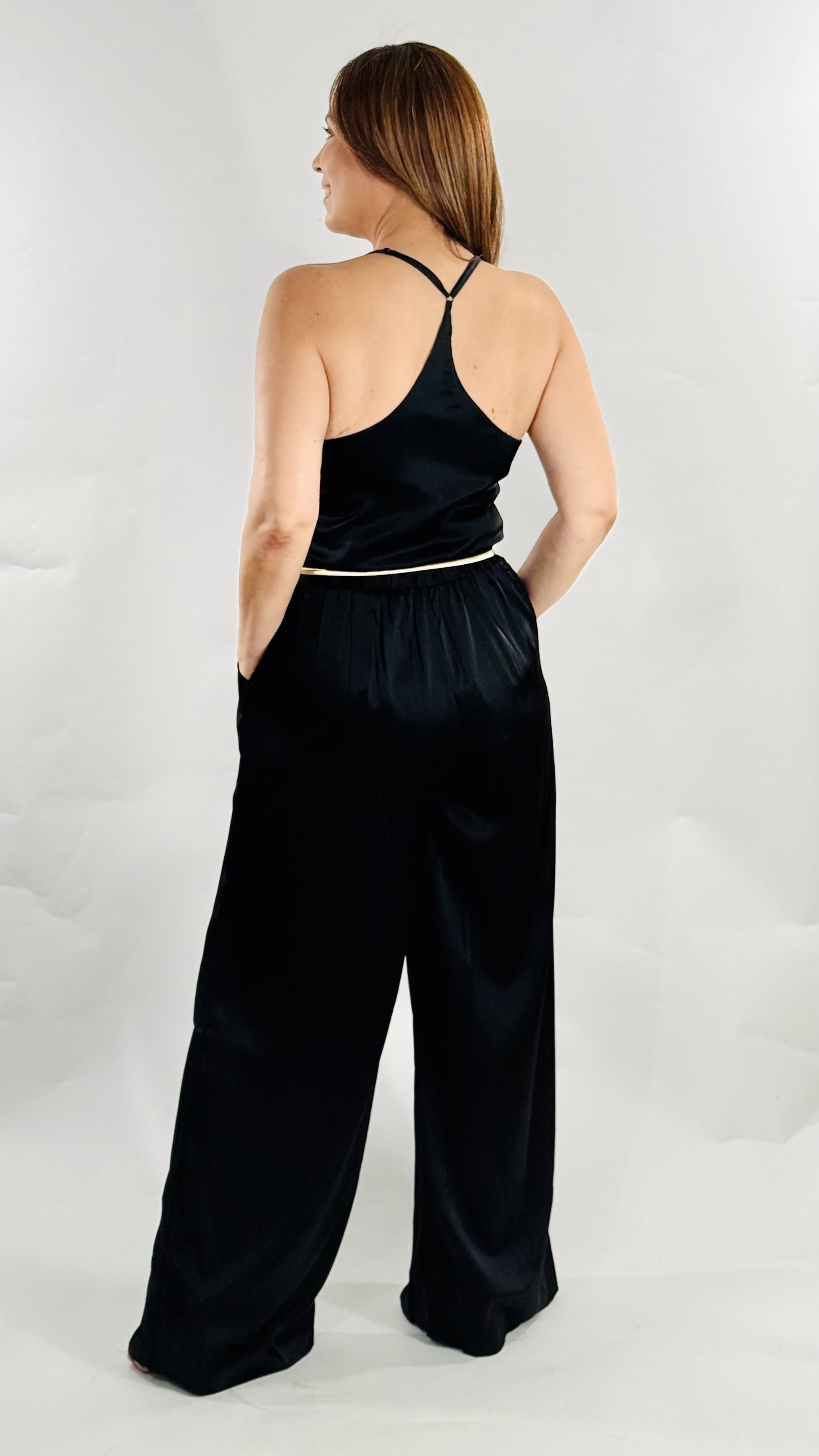 et negro elegante con top de tirantes ajustables y pantalón ancho con bolsillos.