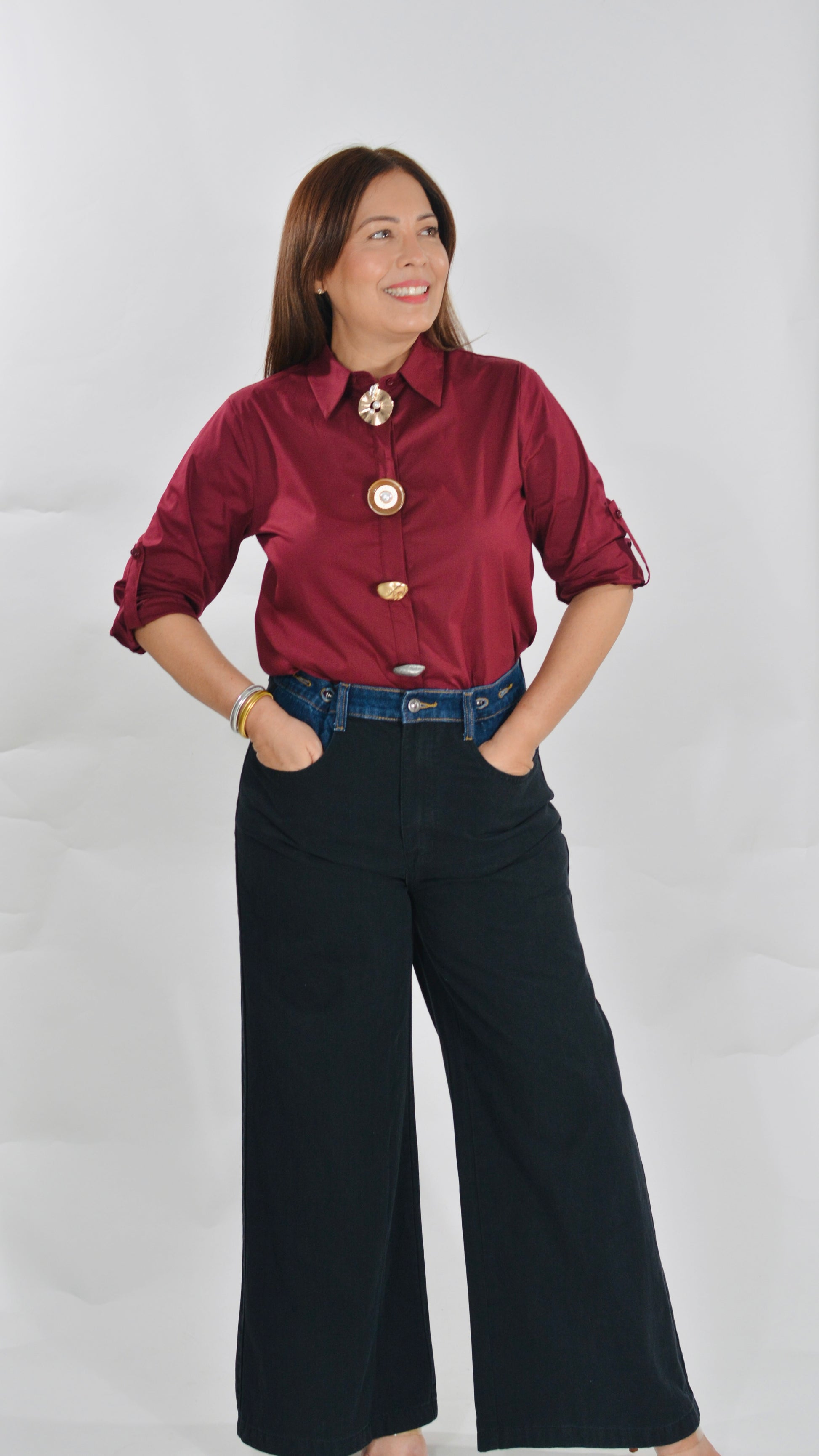 Blusa color vino con botones decorativos y mangas ajustables.