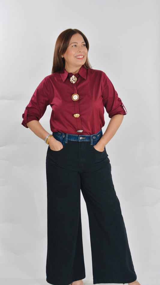 Blusa color vino con botones decorativos y mangas ajustables.