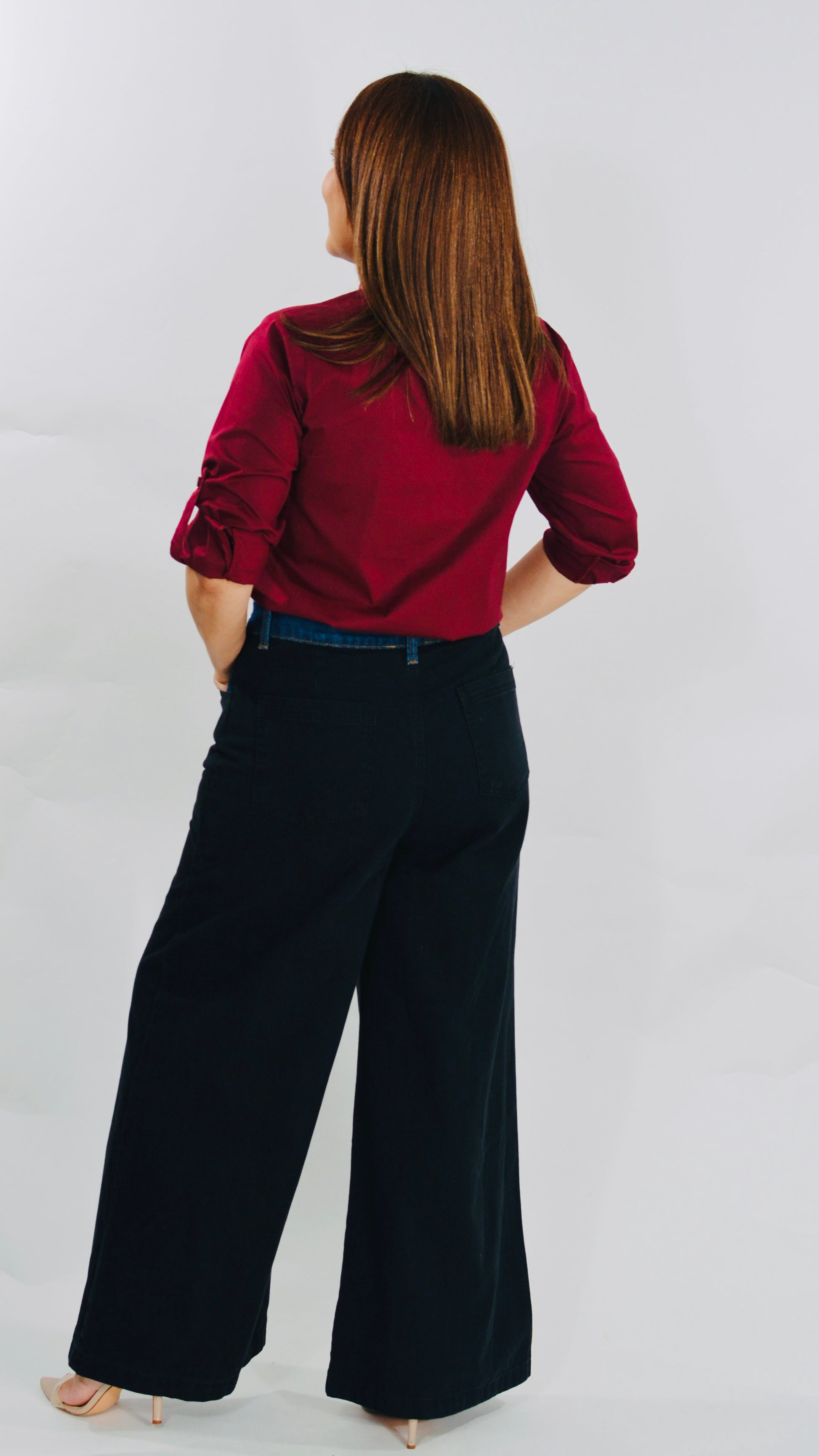 Blusa color vino con botones decorativos y mangas ajustables.